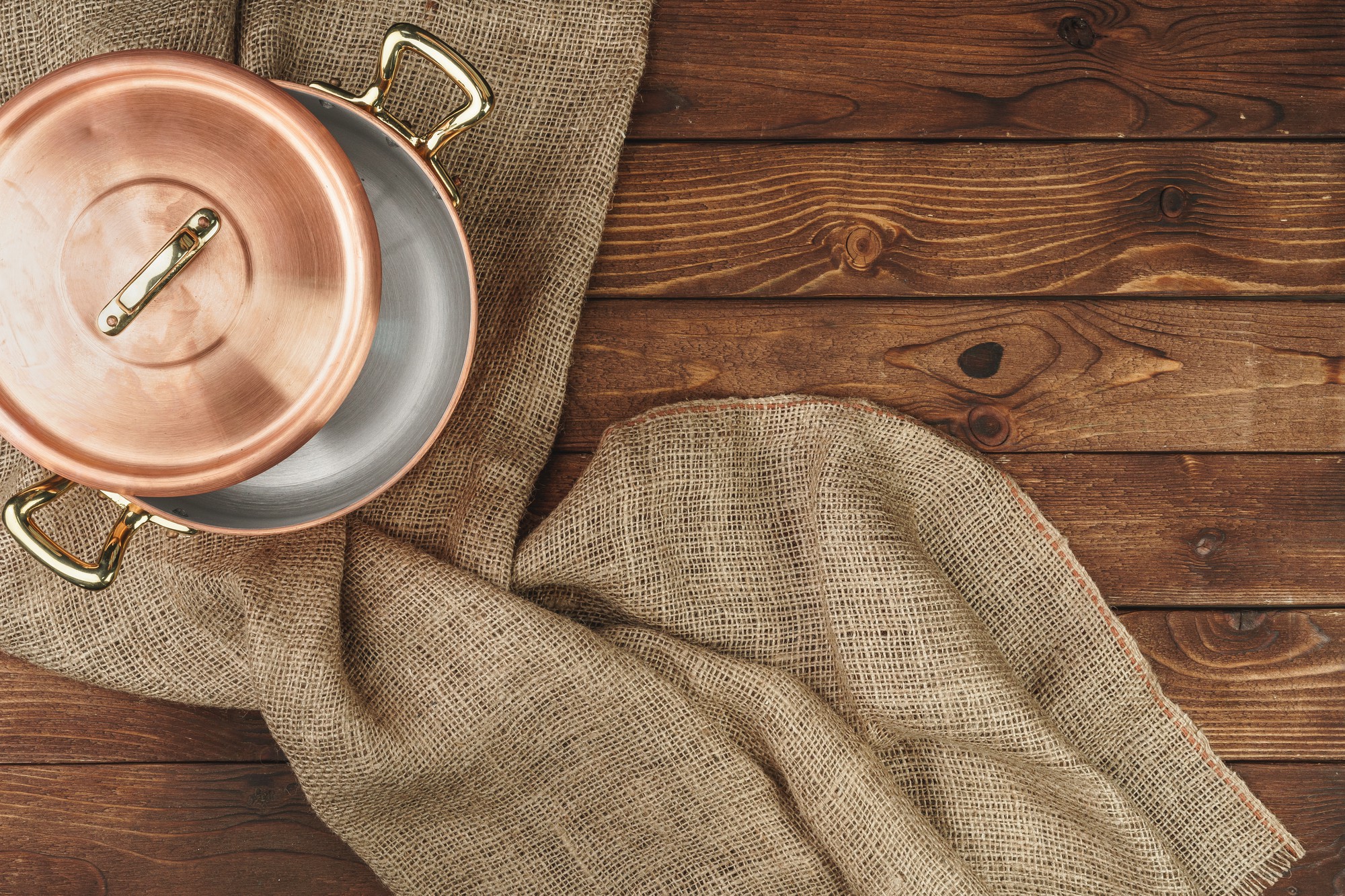 Set of copper pans and folded towels in a warm light
